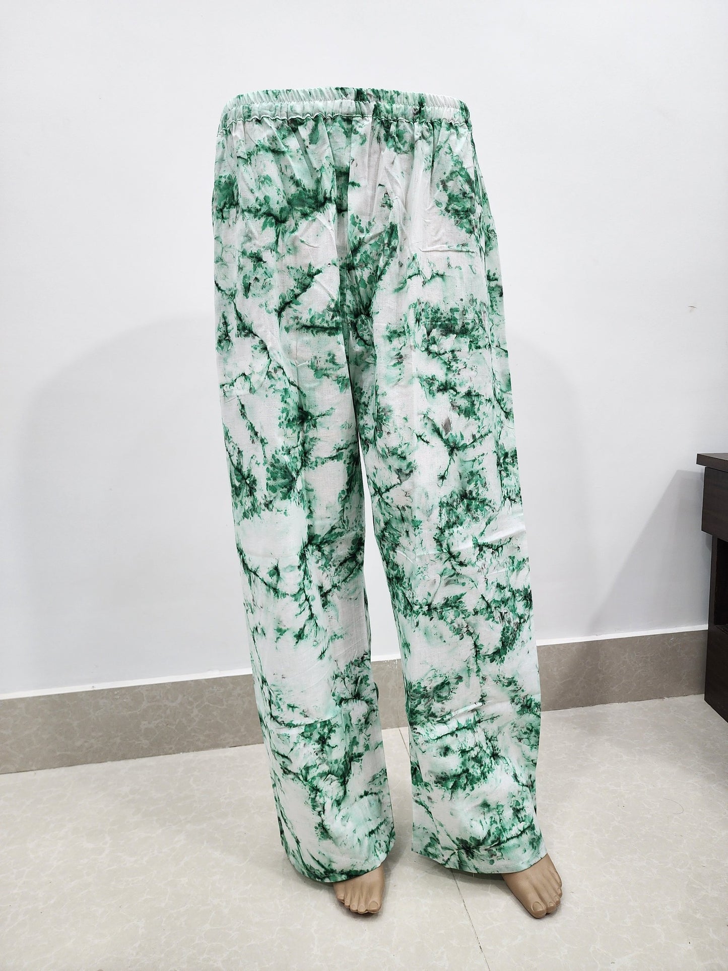 Green and white patterned pants on a plain background