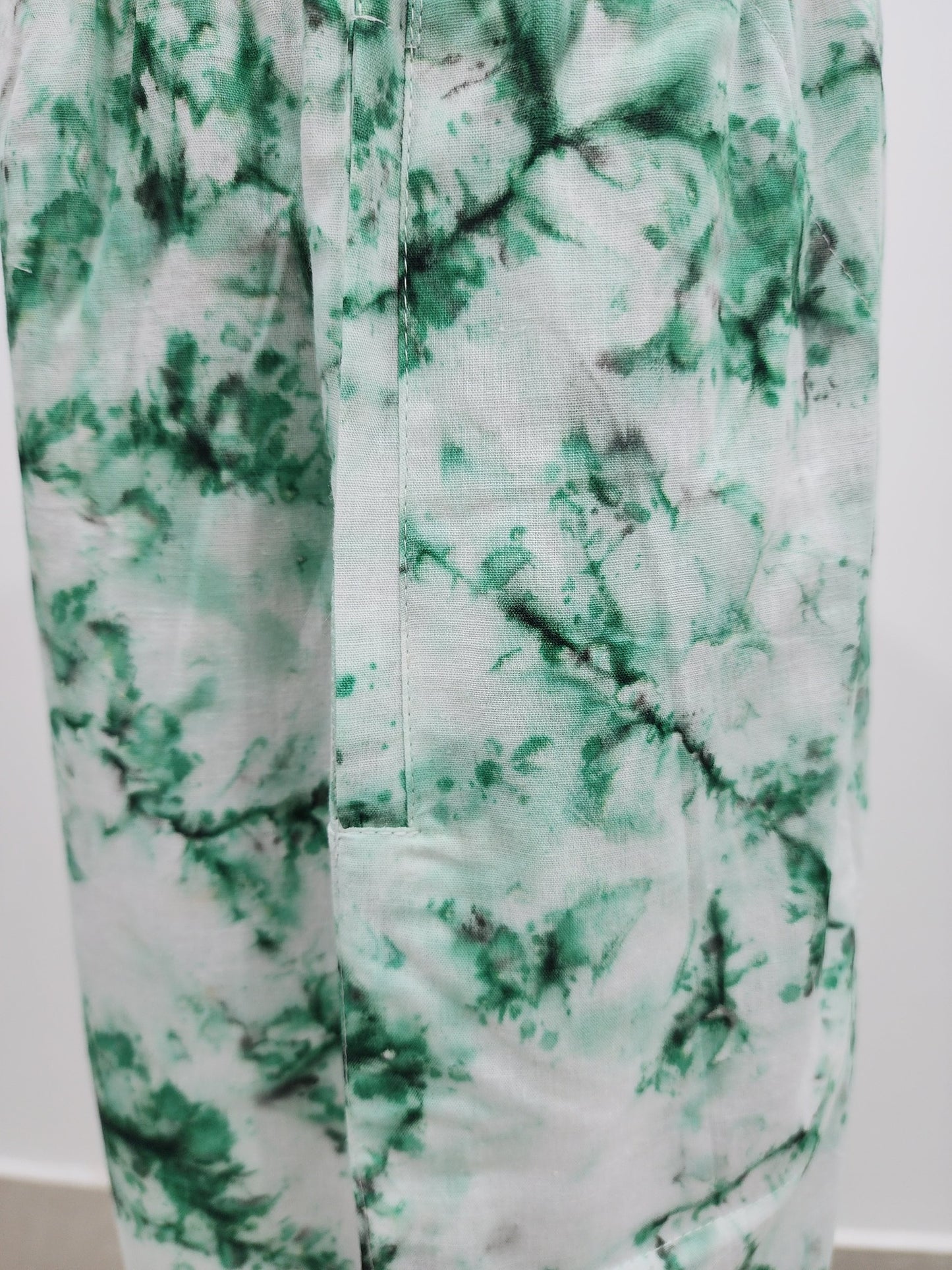 Green and white tie-dye pattern on a plain background