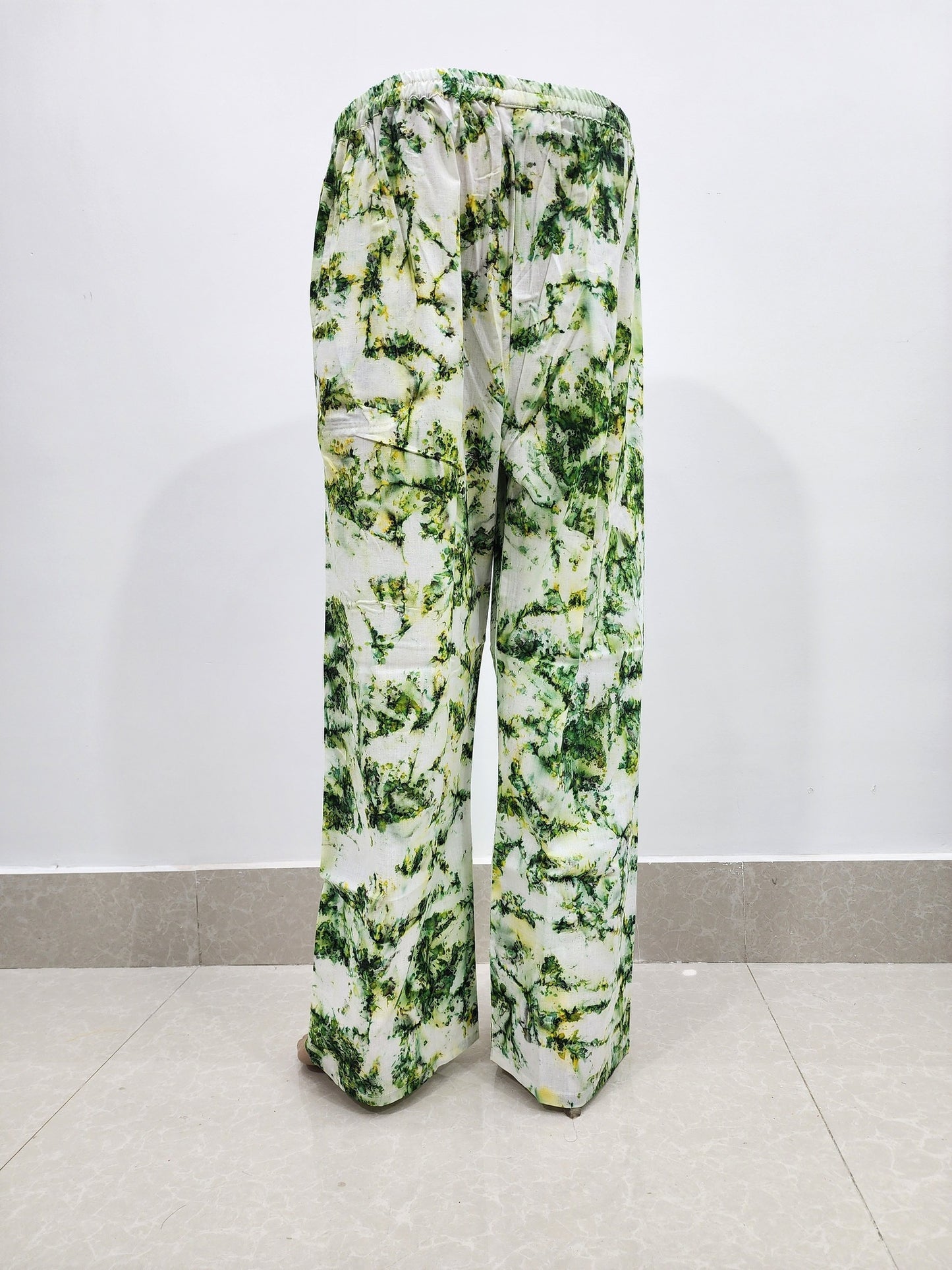 Green and white floral-patterned pants on a white background