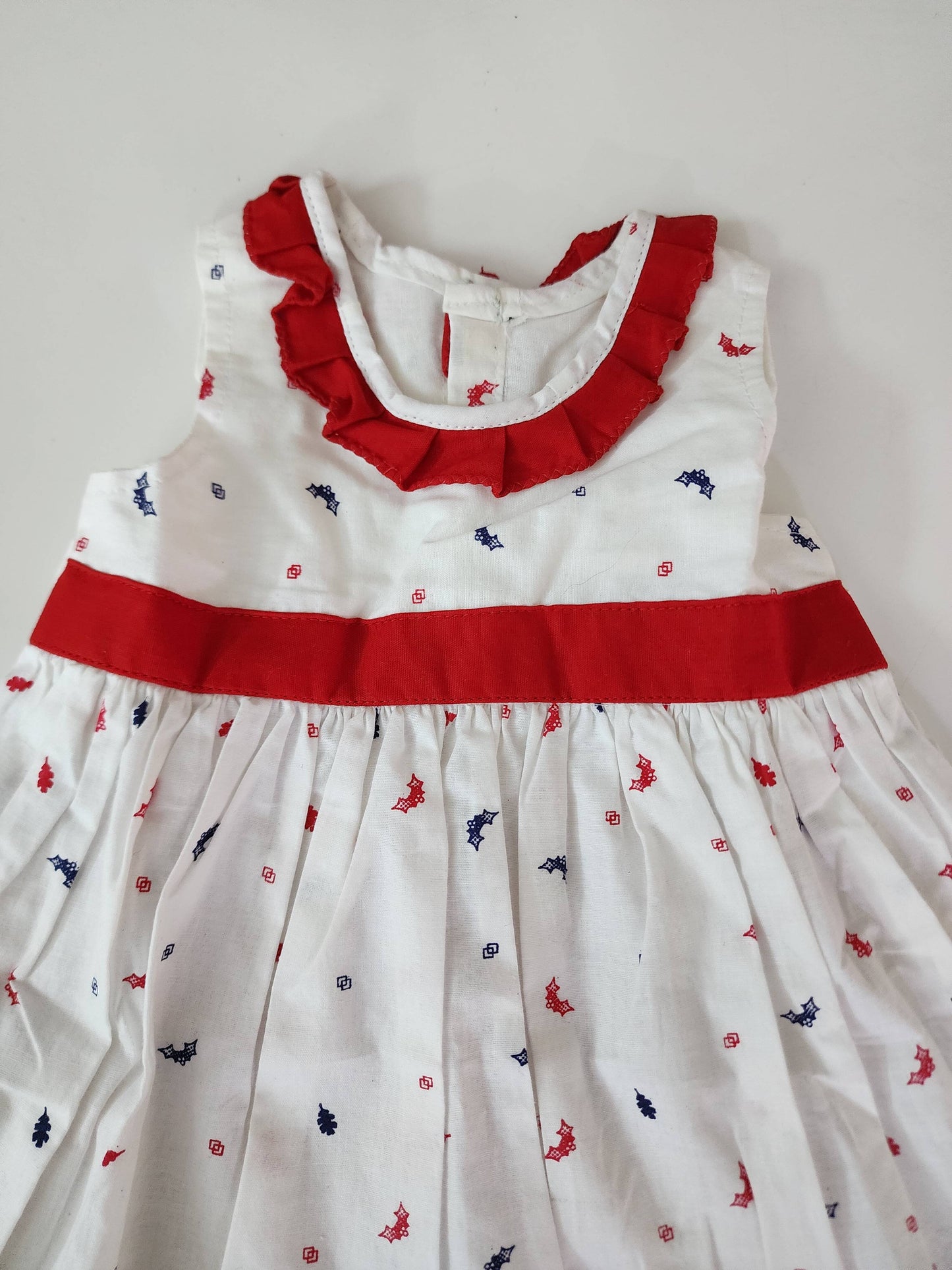 A lovely white cotton frock with a charming print and red lace