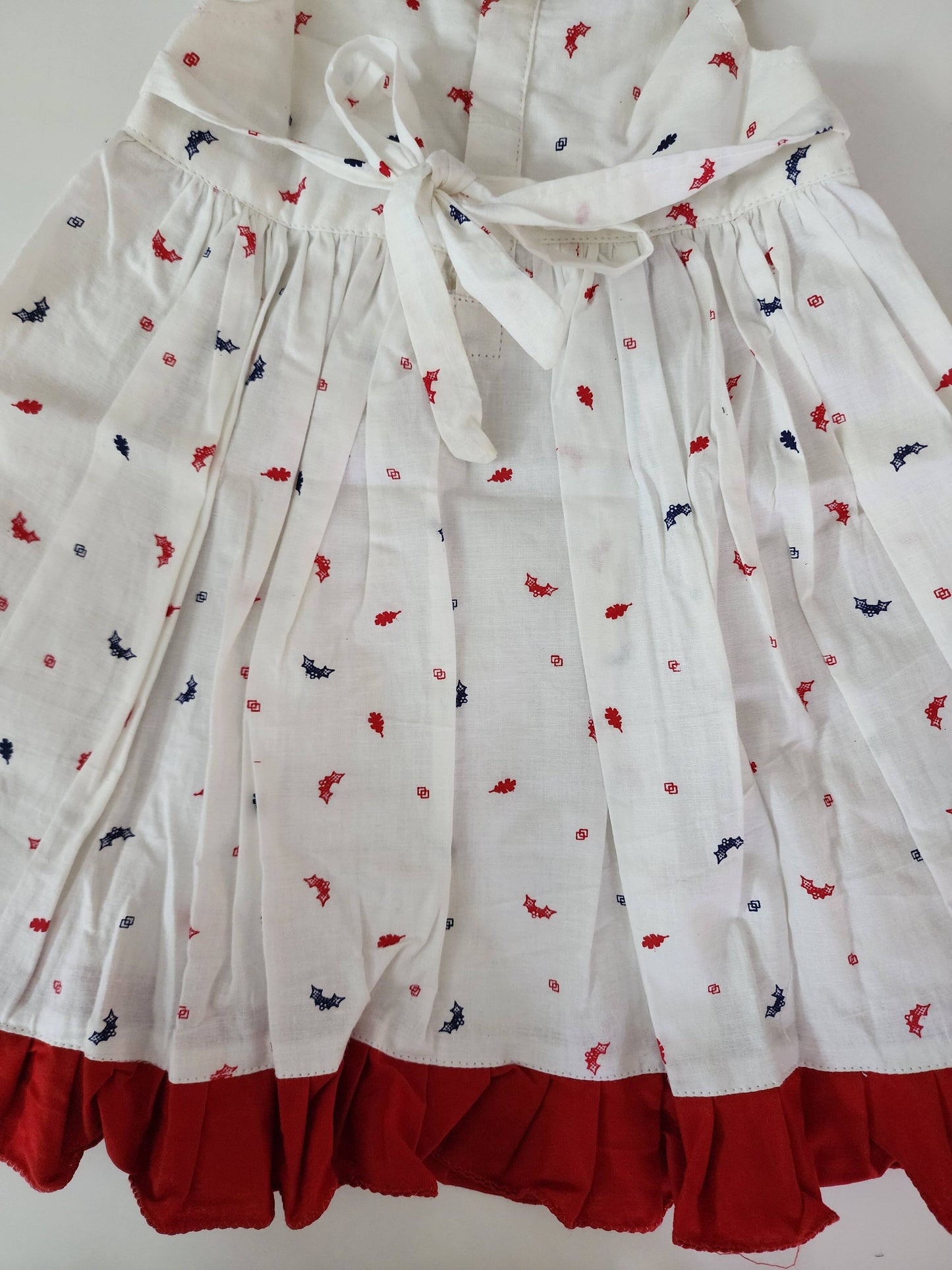 A lovely white cotton frock with a charming print and red lace
