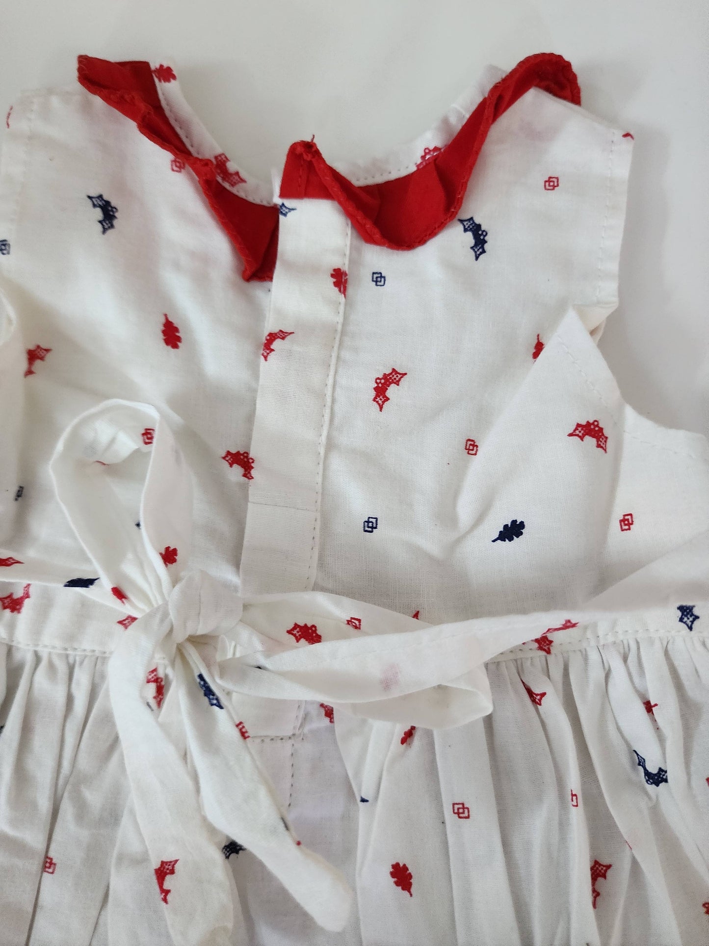 A lovely white cotton frock with a charming print and red lace