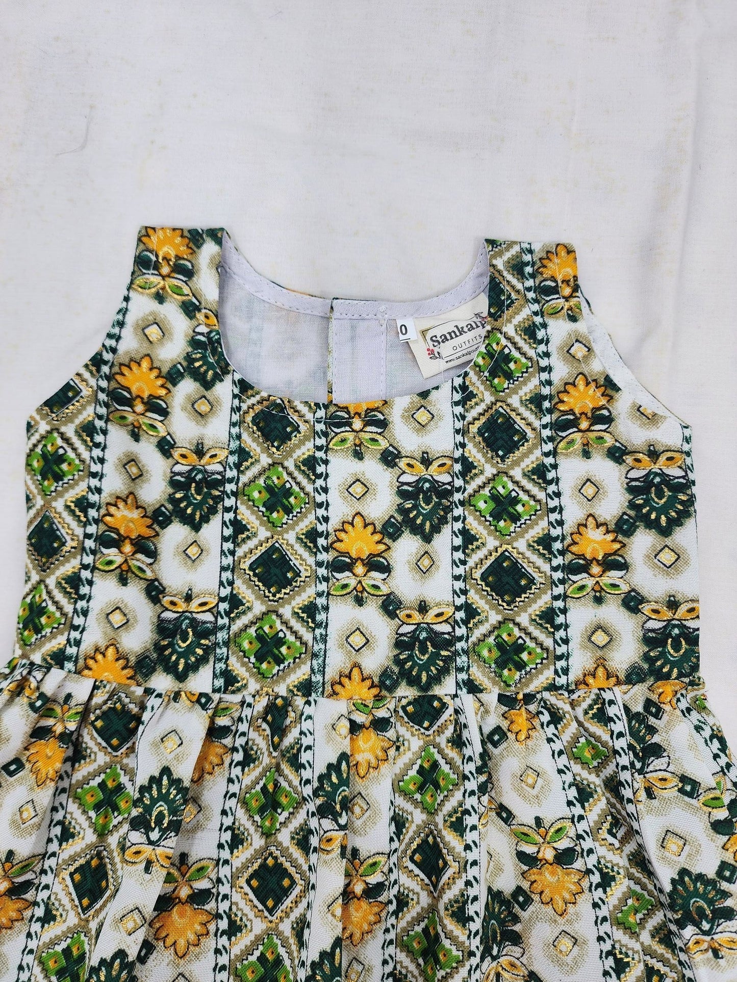 Decorative top with green and yellow patterns on a white background