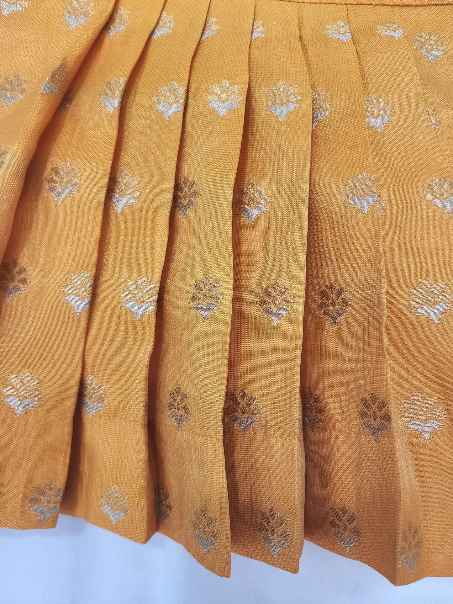 Mustard yellow fabric with floral patterns on a white background