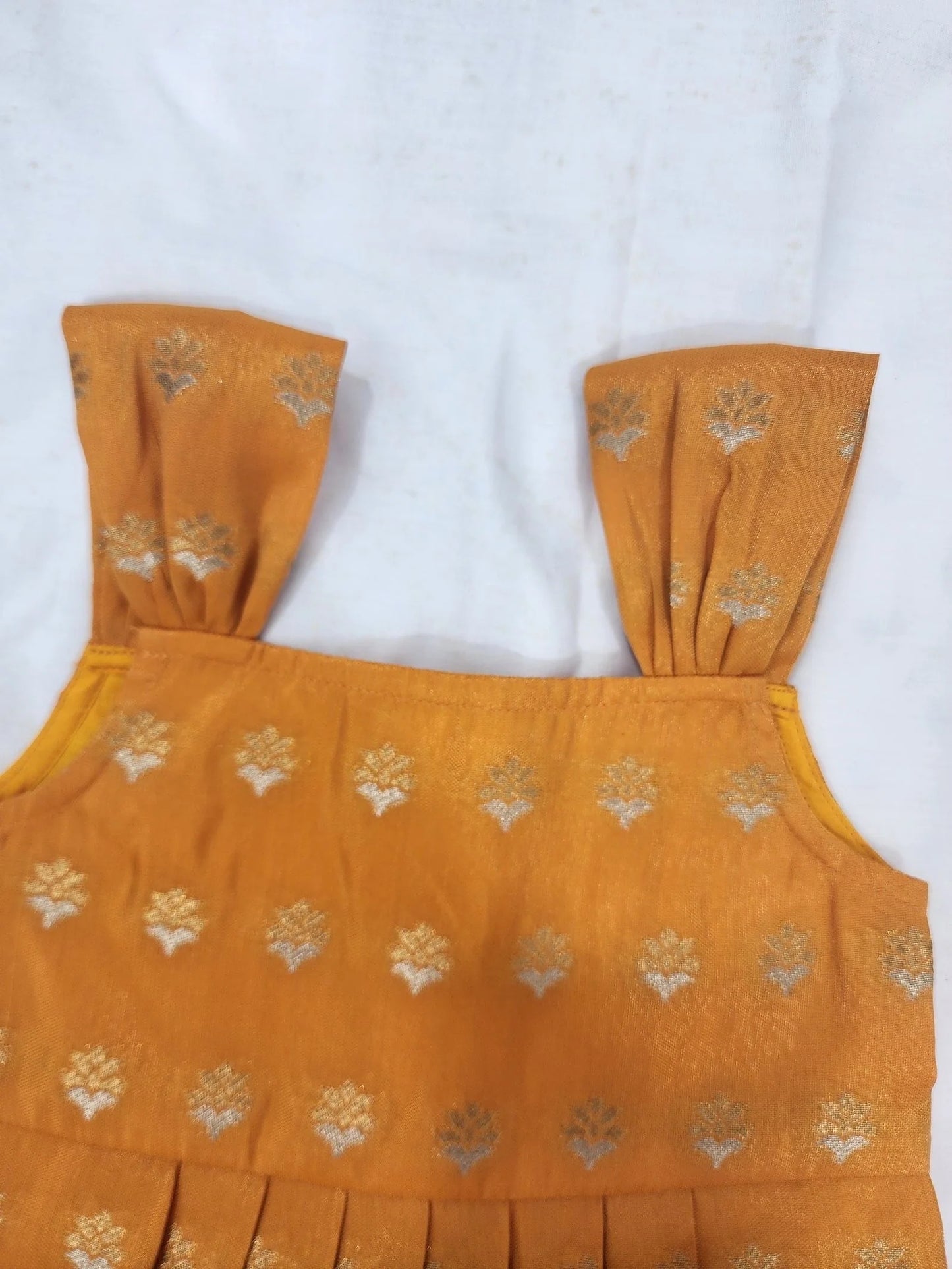 Yellow top with floral patterns on a white background
