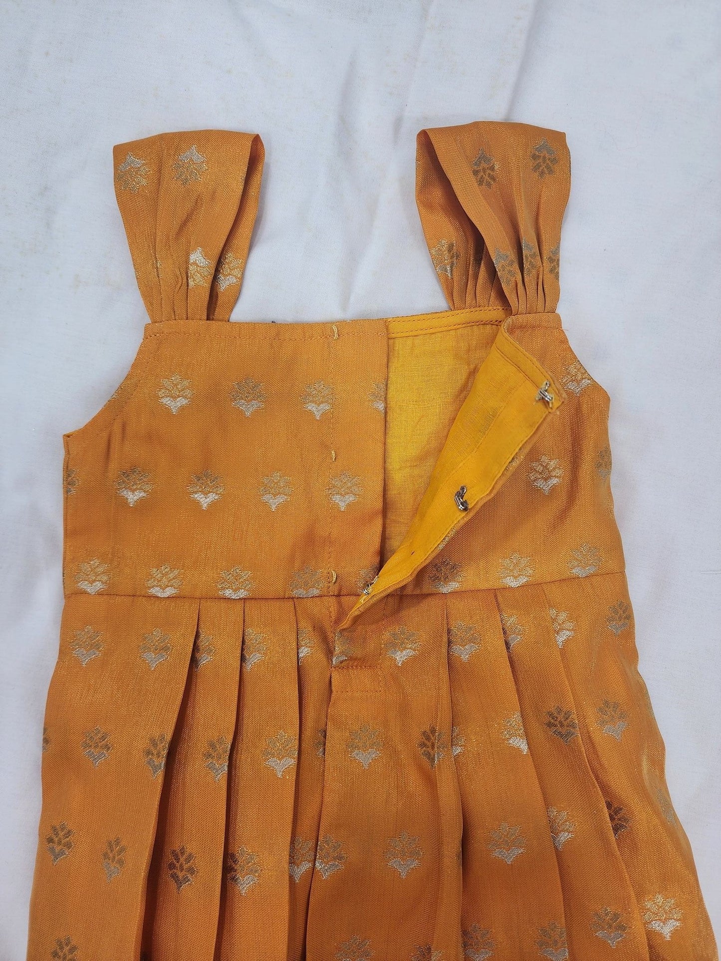Mustard yellow dress with floral patterns on a white background
