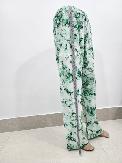 Green and white floral pants with a measuring tape draped over them on a white background