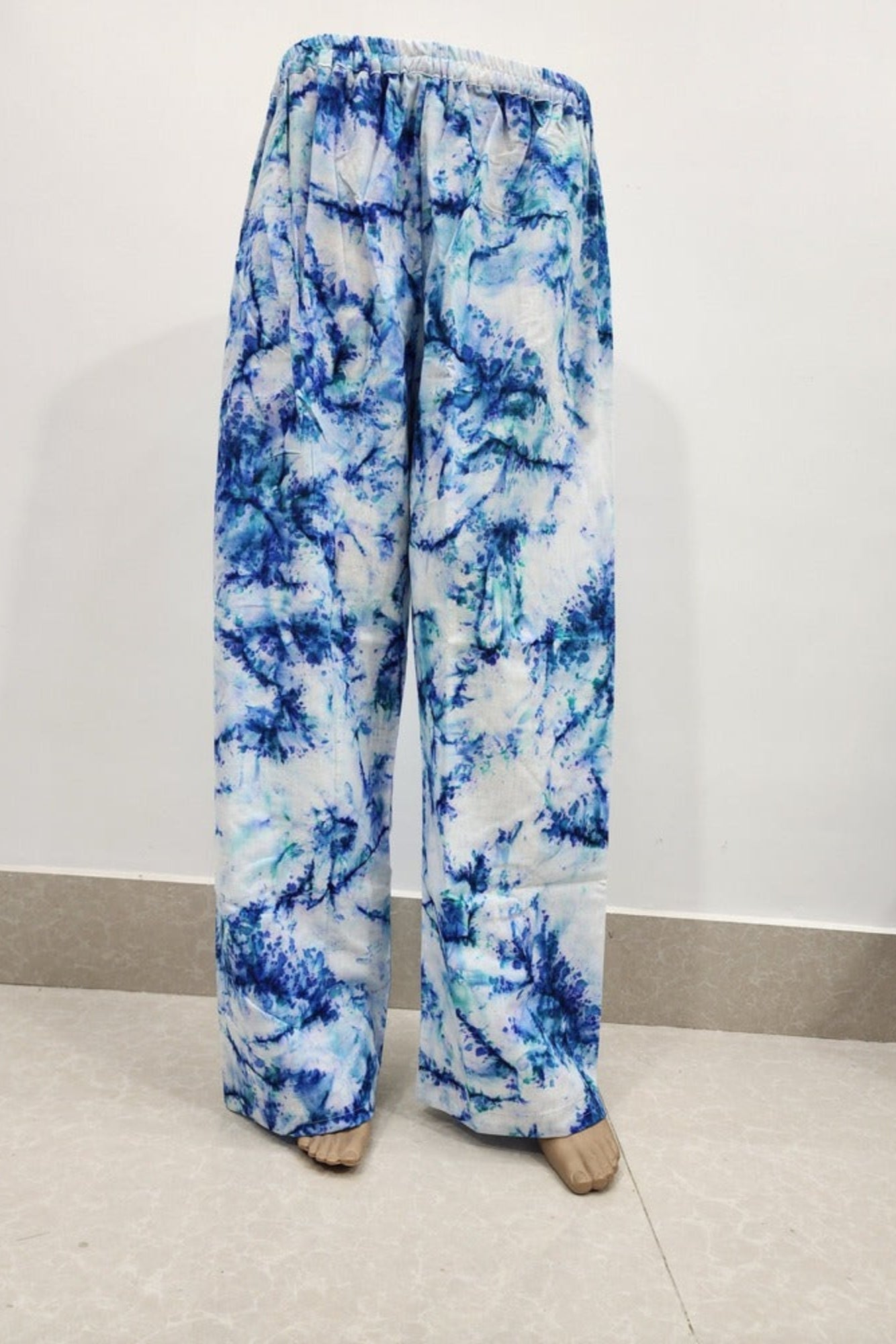 Blue and white tie-dye pants on a plain background
