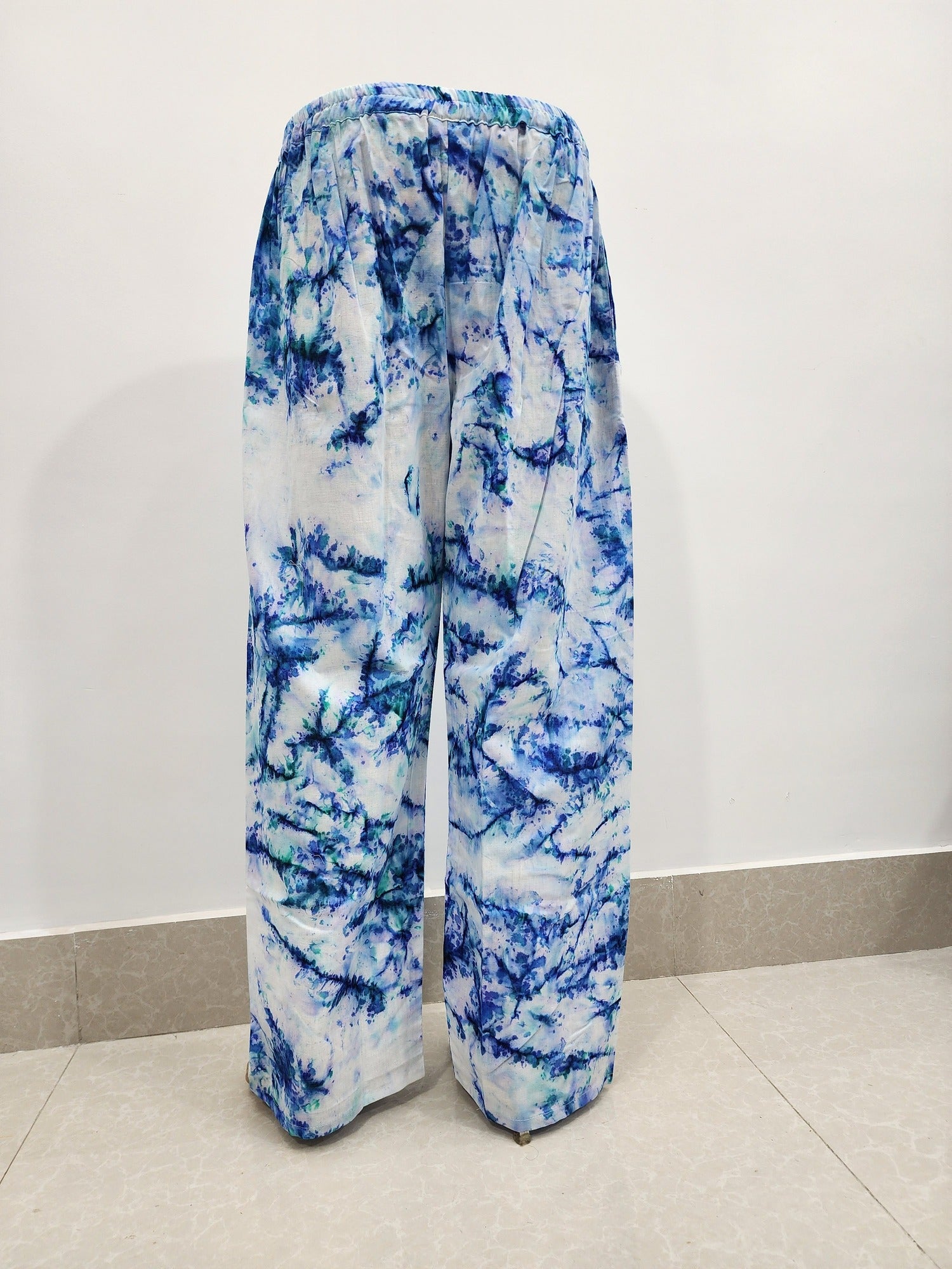Blue and white tie-dye pants on a plain background
