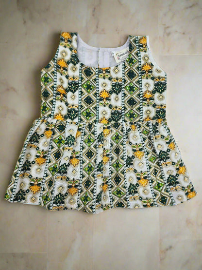Embroidered top with floral and geometric pattern on a white background