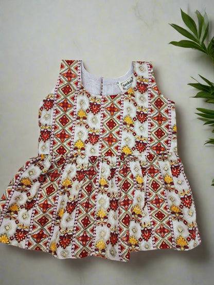 Children's dress with red, white, and yellow pattern on a light gray background