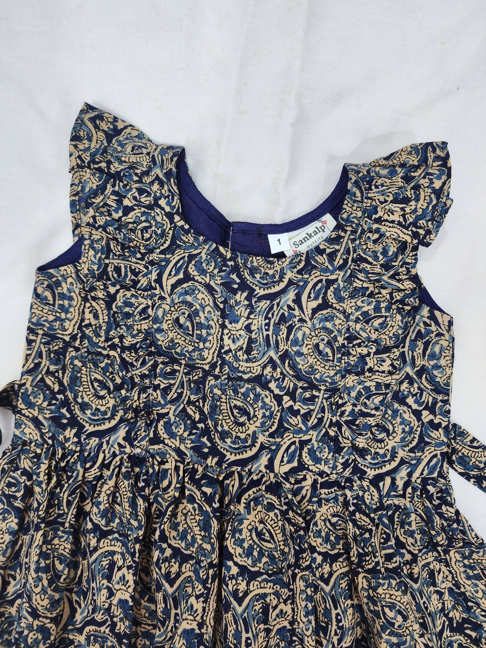 Children's dress with blue and gold paisley pattern on a white background